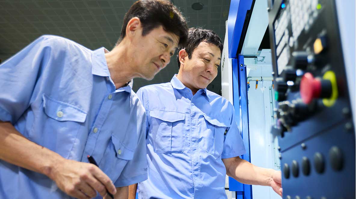 工作機械の点検をする山口さんと岩井さんの写真